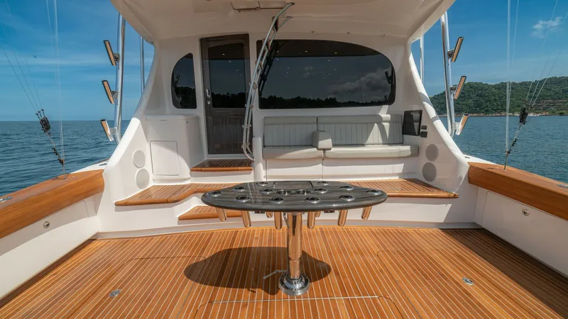 Slide: The Image of Spacious Aft Deck with Seating The aft deck of the 2024 Viking 64 Convertible features a beautifully crafted teak flooring, providing both durability and elegance. A central fighting chair is surrounded by ample seating, perfect for relaxation or social gatherings. The area is designed - 7162586