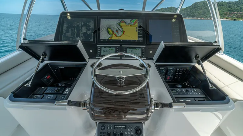 Slide: The Image of State-of-the-Art Helm Station The helm station of the 2024 Viking 64 Convertible 'Fish Tank' showcases cutting-edge navigation technology with multiple high-resolution displays. The polished wood steering wheel is complemented by an array of intuitive controls, ensuring precision and - 7162589