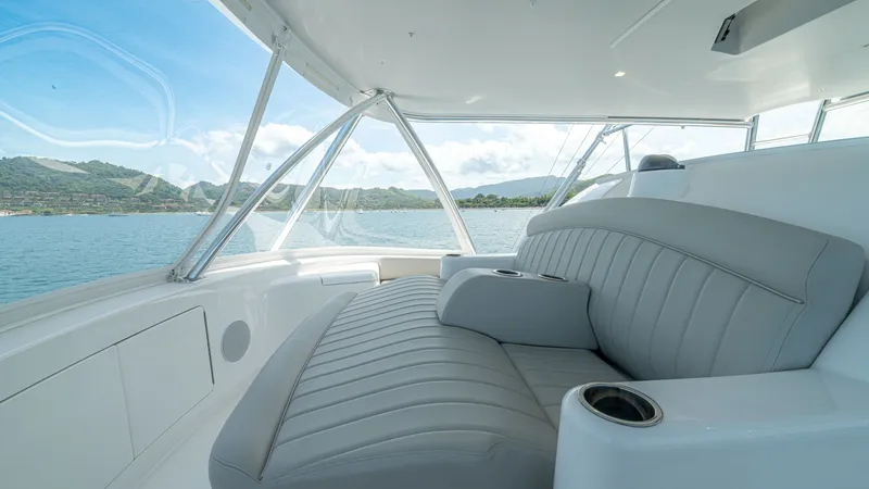 Slide: The Image of Flybridge Seating with Panoramic View The flybridge of the Viking 64 Convertible offers plush, contoured seating, ideal for comfort and relaxation. The expansive windows provide a panoramic view of the surrounding seascape, enhancing the open-air experience. With integrated cup holders and a - 7162597