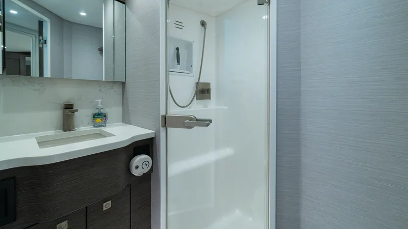 Slide: The Image of Elegant Ensuite Bathroom This sophisticated ensuite bathroom features a sleek, walk-in shower with modern fixtures, complemented by a stylish vanity with ample storage. The contemporary design is enhanced by soft lighting and high-quality finishes, offering a luxurious and functi - 7162574