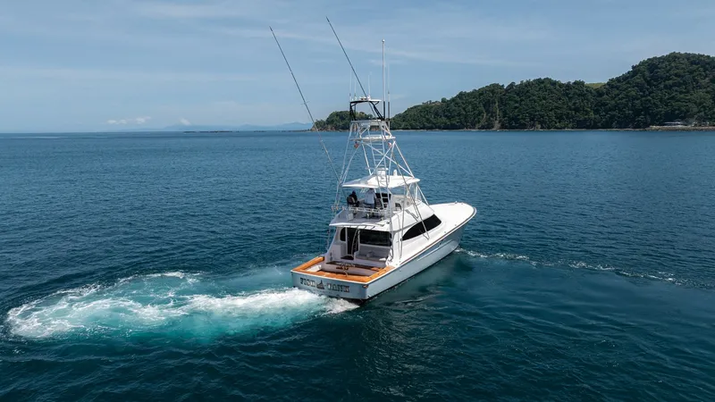Slide: The Image of Aft View with Tower and Cockpit This image captures the sleek aft view of the 2024 Viking 64 Convertible, 'Fish Tank,' showcasing its impressive tower and spacious cockpit. The vessel glides gracefully through the water, highlighting its powerful performance and elegant design. Perfect - 7162617