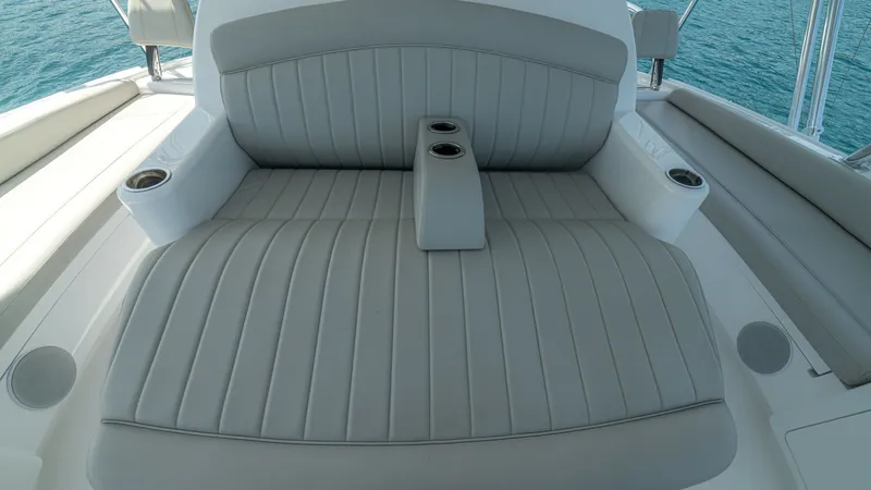 Slide: The Image of Flybridge Lounge Seating This image showcases the luxurious lounge seating on the flybridge of the 2024 Viking 64 Convertible. The seating features plush, light gray upholstery with integrated cup holders for convenience. The ergonomic design and spacious layout provide a perfect - 7162598