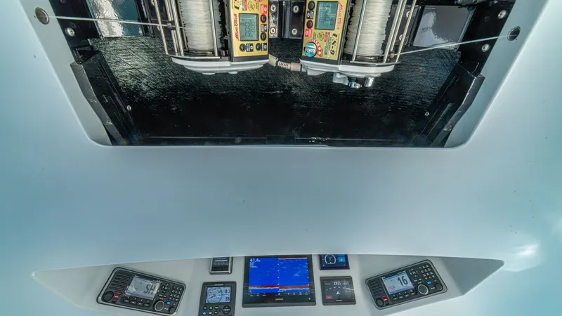 Slide: The Image of Cockpit Electronics and Reel Controls This image showcases the advanced cockpit electronics and reel controls on the 2024 Viking 64 Convertible. The display features state-of-the-art navigation and communication tools, ensuring optimal performance and safety at sea. Above, the integrated reel - 7162594