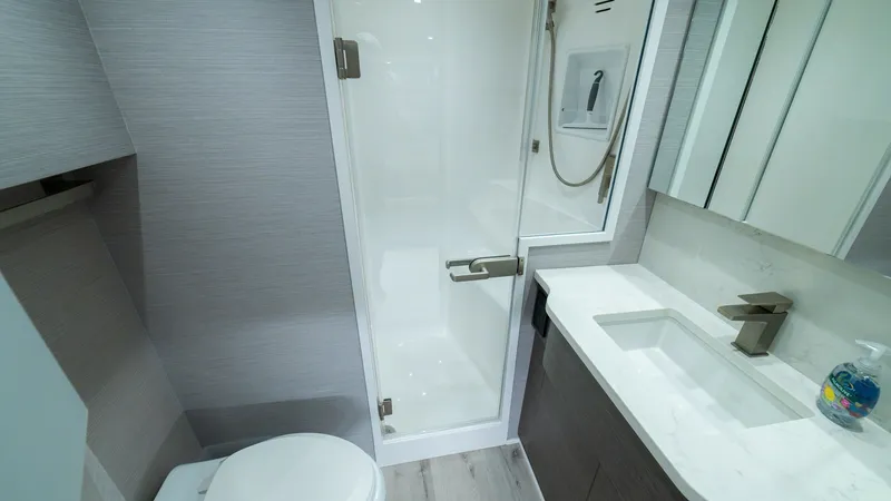 Slide: The Image of Modern Ensuite Bathroom This sleek ensuite bathroom on the 2024 Viking 64 Convertible features a contemporary design with high-end finishes. It includes a spacious glass-enclosed shower, elegant marble countertop, and ample storage. The modern lighting and polished fixtures crea - 7162572