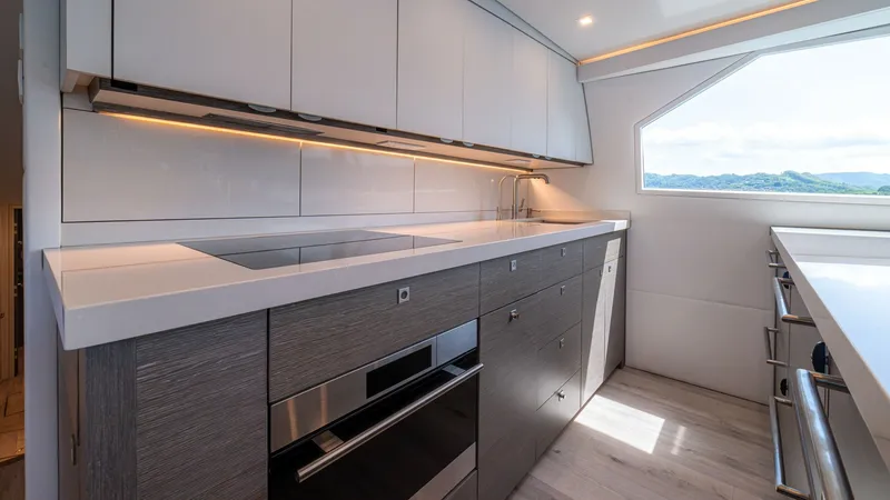 Slide: The Image of Modern Galley with Panoramic View The galley of the 2024 Viking 64 Convertible features sleek cabinetry with integrated lighting, creating an inviting and functional space. High-end appliances are seamlessly built into the contemporary design, complemented by expansive windows that offer - 7162549