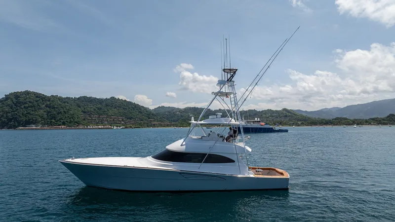 Slide: The Image of Side Profile of Viking 64 Convertible The 2024 Viking 64 Convertible 'Fish Tank' is showcased in an elegant side profile, highlighting its sleek hull and sophisticated design. The vessel features a well-equipped flybridge with outriggers, emphasizing its readiness for sportfishing adventures. - 7162611