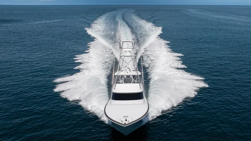 Slide: The Image of Aerial View of Bow in Motion This striking image captures the 2024 Viking 64 Convertible 'Fish Tank' from an aerial perspective, showcasing its sleek bow cutting through the water. The vessel's impressive wake highlights its powerful performance and advanced design. The open ocean se - 7162625