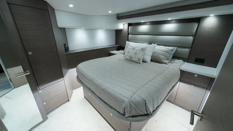 Slide: The Image of Luxurious Master Stateroom The master stateroom aboard the 2024 Viking 64 Convertible exudes elegance with its plush bedding and modern design. Soft overhead lighting and sleek wood finishes create a warm, inviting atmosphere. Ample storage and contemporary styling ensure comfort a - 7162569