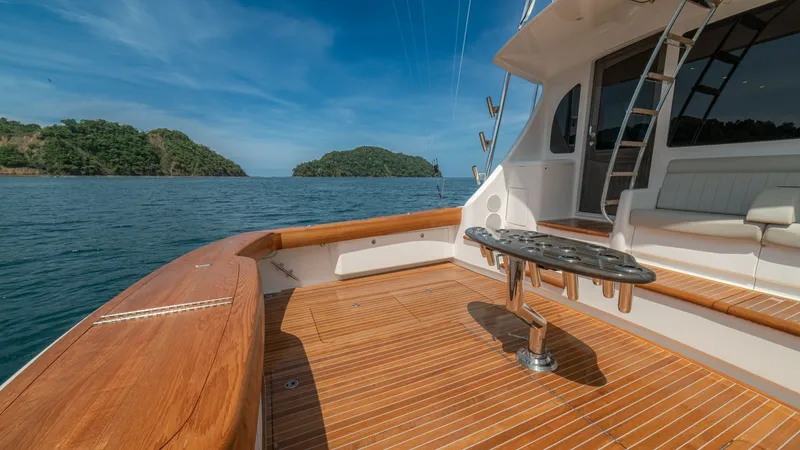 Slide: The Image of Spacious Aft Deck with Teak Flooring The aft deck of the Viking 64 Convertible showcases luxurious teak flooring, providing a warm, inviting space for relaxation and entertaining. A central fighting chair is perfectly positioned for sport fishing enthusiasts, while ample bench seating offers - 7162585
