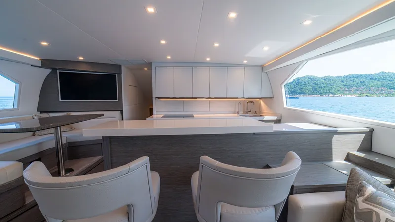 Slide: The Image of Salon / Galley This elegant salon on the 2024 Viking 64 Convertible features sleek, contemporary design with ample natural light streaming through large windows. The space boasts comfortable seating, a stylish bar area, and integrated entertainment system. High-end fini - 7162547