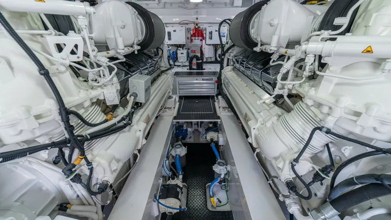 Slide: The Image of Engine Room with Dual Engines This image showcases the meticulously designed engine room of the 2024 Viking 64 Convertible, featuring dual powerful engines. The space is expertly organized, allowing easy access to essential components, with pristine white finishes enhancing the clean - 7162605