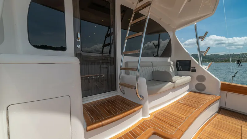 Slide: The Image of Cockpit Entry and Seating Area This inviting cockpit area on the 2024 Viking 64 Convertible features elegant teak decking and a seamless transition to the interior through a glass door. A comfortable built-in bench provides a relaxing seating option, complemented by a polished stainles - 7162577