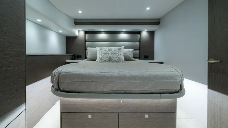 Slide: The Image of Luxurious Master Stateroom This elegant master stateroom on the 2024 Viking 64 Convertible exudes sophistication and comfort. The space features a plush queen-sized bed with modern, soft-touch fabric and ambient recessed lighting. Rich wood finishes and ample storage create a seren - 7162542