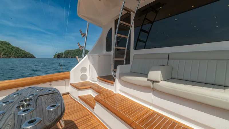 Slide: The Image of Spacious Aft Deck with Seating The aft deck of the 2024 Viking 64 Convertible features elegant teak flooring and a comfortable, cushioned seating area, perfect for relaxation. The area is equipped with a sleek ladder leading to the upper deck, enhancing both functionality and style. Th - 7162581