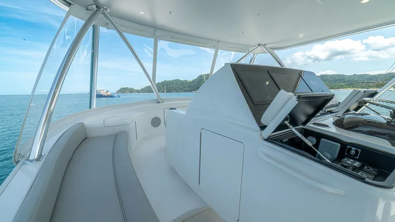 Slide: The Image of Flybridge Helm Station The flybridge helm station of the 2024 Viking 64 Convertible offers a sleek, modern design with state-of-the-art navigation equipment. The panoramic windows provide expansive ocean views, enhancing the open and airy feel of the space. Comfortable seating - 7162595