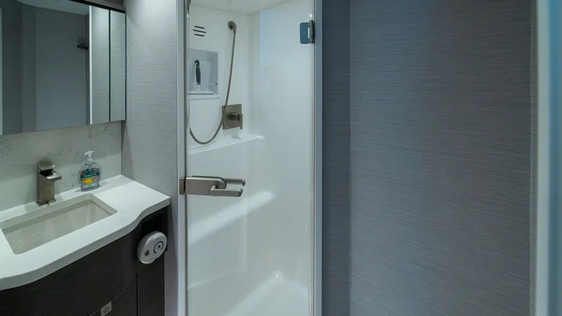 Slide: The Image of Ensuite Bathroom with Shower This sleek ensuite bathroom on the 2024 Viking 64 Convertible features a modern shower with a glass door and contemporary fixtures. The vanity area is equipped with a stylish sink and mirrored storage, offering both elegance and functionality. High-qualit - 7162575