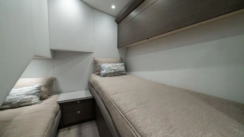 Slide: The Image of Twin Guest Stateroom The twin guest stateroom features elegant, contemporary design with two plush single beds and soft, ambient overhead lighting. Rich wood cabinetry offers ample storage, complementing the neutral tones of the bedding. This space is designed for comfort and - 7162559