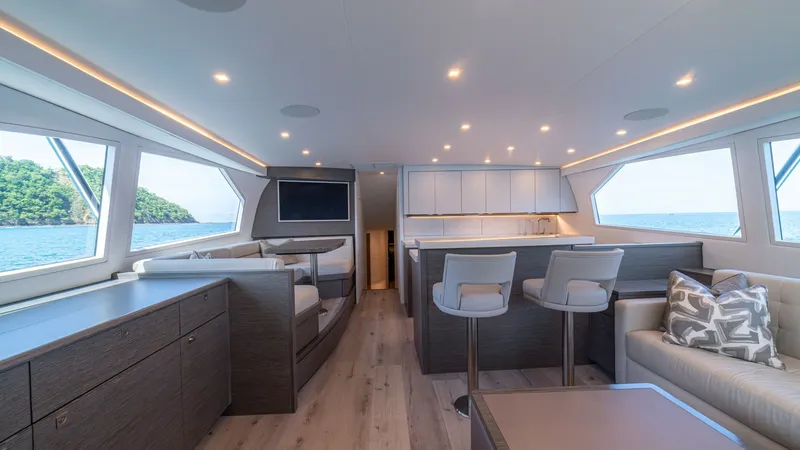 Slide: The Image of Salon with Ocean Views The salon of the 2024 Viking 64 Convertible 'Fish Tank' offers a modern and inviting space with expansive windows providing stunning ocean views. The contemporary design features sleek cabinetry, plush seating, and a well-appointed bar area, creating an i - 7162543