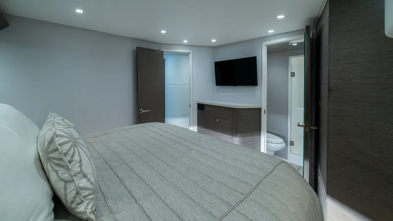 Slide: The Image of Luxurious Master Stateroom This elegant master stateroom on the 2024 Viking 64 Convertible offers a spacious and serene retreat. Featuring a plush, king-sized bed with premium bedding, it is complemented by modern, recessed lighting and sleek wood cabinetry. The en-suite bathroom a - 7162571