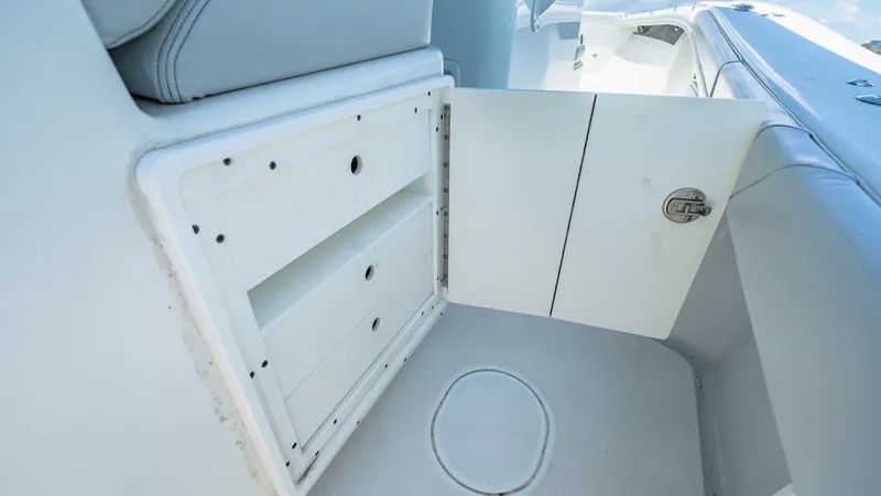Slide: The Image of Cockpit Storage Compartment Access This image showcases the storage compartment in the cockpit area of the 2021 Yellowfin 36 Offshore. The compartment door opens to reveal ample space for organizing essential equipment or personal items. The clean, streamlined design and durable materials - 7150900
