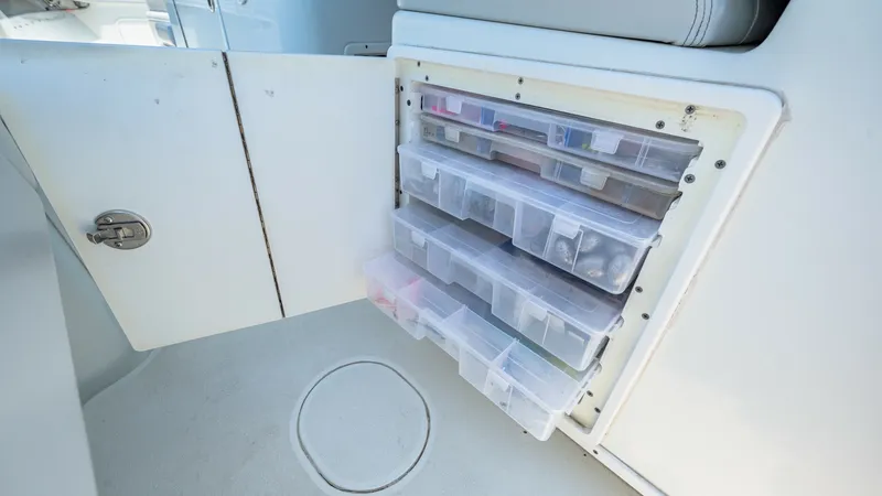 Slide: The Image of Onboard Tackle Storage Compartment This image showcases the tackle storage compartment on the 2021 Yellowfin 36 Offshore. The built-in design offers multiple clear, easily accessible drawers, perfect for organizing fishing gear efficiently. The sleek integration into the seating area maxim - 7150899