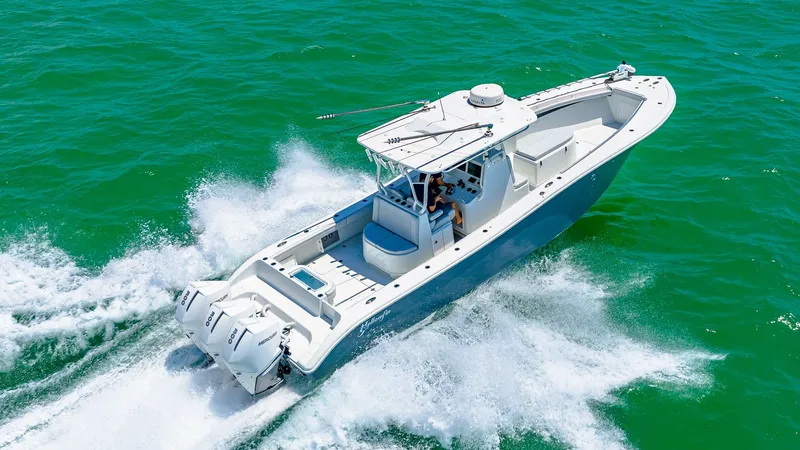 Slide: The Image of Aerial View of Center Console This image showcases the sleek design of the 2021 Yellowfin 36 Offshore, highlighting its spacious center console layout. The boat's powerful triple outboard engines and agile hull design ensure impressive speed and performance on the water. The expansive - 7150932