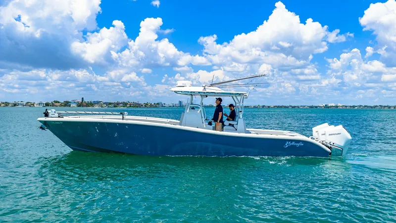 Slide: The Image of Side View of 2021 Yellowfin 36 Offshore This image showcases the sleek profile of the 2021 Yellowfin 36 Offshore, emphasizing its robust hull design and spacious deck area. The vessel is equipped with powerful outboard engines, ideal for offshore adventures. Its T-top provides ample shade, enha - 7150877