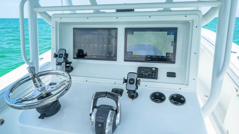 Slide: The Image of Helm Station with Dual Displays The 2021 Yellowfin 36 Offshore features a sleek helm station equipped with dual multifunction displays for optimal navigation and control. The ergonomic layout includes a stainless steel steering wheel and advanced throttle controls, ensuring precise hand - 7150892