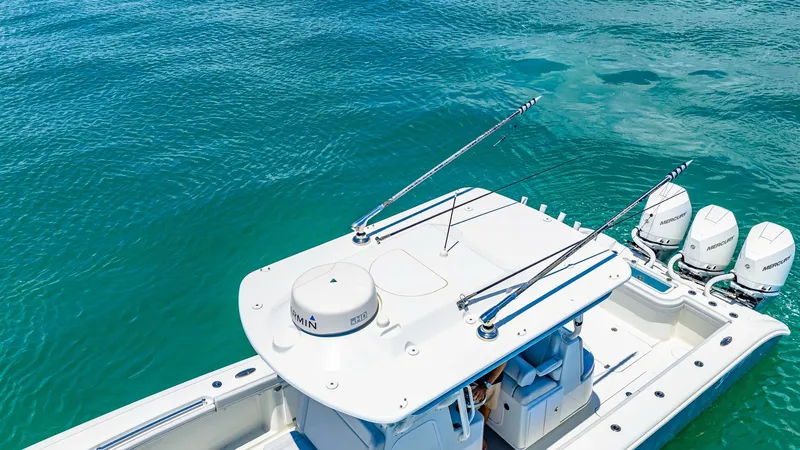 Slide: The Image of Overhead View of Helm and Outboards This image showcases the sleek helm area and triple outboard engines of the 2021 Yellowfin 36 Offshore. The T-top provides ample shade and houses advanced navigation equipment, emphasizing the vessel's readiness for serious offshore adventures. The powerf - 7150872