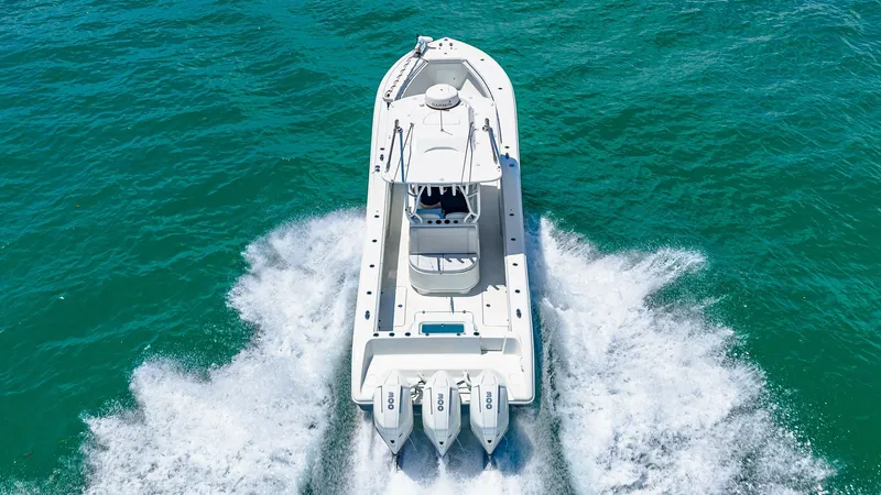 Slide: The Image of Aerial View of Aft Deck and Engines This image showcases the dynamic aft deck of the 2021 Yellowfin 36 Offshore, highlighted by its powerful triple-engine setup. The clean, spacious deck design is perfect for fishing or leisure activities, providing ample room for movement. The sleek hull c - 7150934