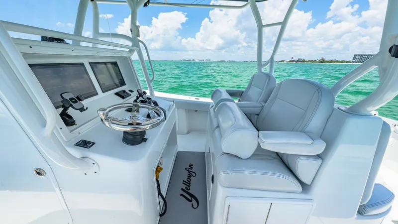 Slide: The Image of Helm Station with Dual Seating The helm station of the 2021 Yellowfin 36 Offshore features a sleek design with dual cushioned captain's chairs, offering comfort and style. The state-of-the-art navigation console is equipped with multiple touch-screen displays, ensuring a seamless and m - 7150890