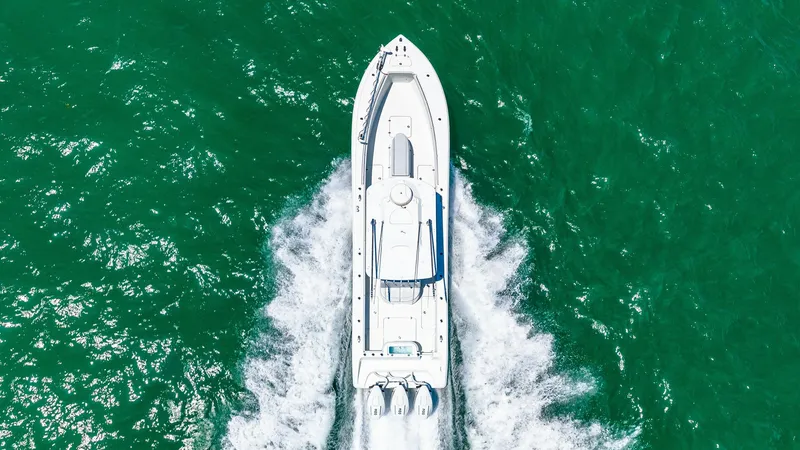 Slide: The Image of Aerial View of 36 Offshore in Motion This aerial shot captures the impressive 2021 Yellowfin 36 Offshore cutting through the water with precision. The sleek hull design and powerful triple outboard engines demonstrate its capability for high-speed cruising. The spacious deck layout is optimi - 7150936