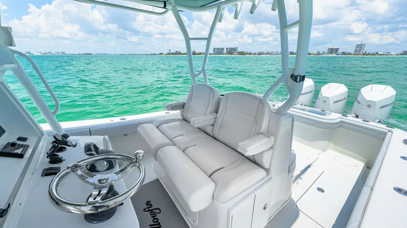 Slide: The Image of Helm Seating and Console View This image showcases the helm area of the 2021 Yellowfin 36 Offshore, featuring plush, ergonomically designed seating with ample cushioning for comfort during long voyages. The sleek stainless-steel steering wheel and modern console layout provide intuiti - 7150893
