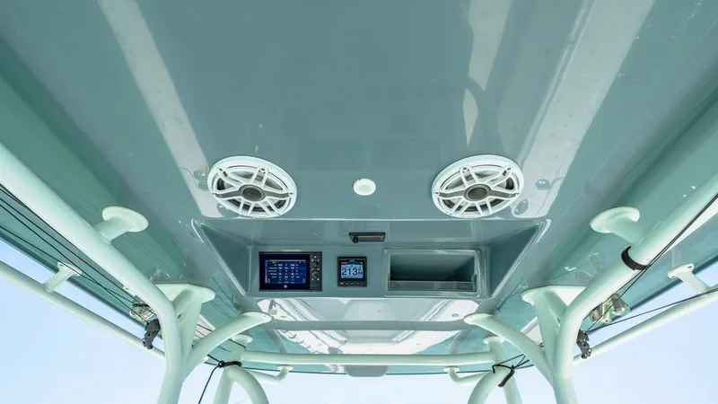 Slide: The Image of T-Top Electronics and Speaker Setup The 2021 Yellowfin 36 Offshore features an advanced T-top setup with integrated electronics and speakers. This design offers easy access to navigation controls and entertainment systems, enhancing both functionality and onboard enjoyment. The sleek, moder - 7150897