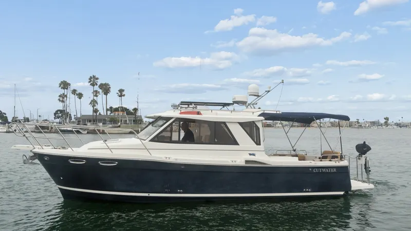 The Image of Starboard Side View of Cutwater 28 This image showcases the elegant starboard profile of the 2014 Cutwater 28 Downeast, featuring a sleek navy hull and a classic cabin design. The vessel's spacious deck is equipped with a protective canopy, ensuring comfort and shade. Notable details inclu - 7180671