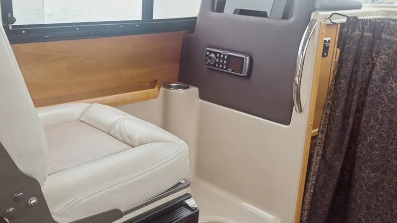 Slide: The Image of Helm Seat and Control Panel This image showcases the helm seat of the 2014 Cutwater 28 Downeast, featuring a plush, cushioned design for maximum comfort during voyages. Adjacent to the seat is the control panel, strategically positioned for easy access, with a sleek finish and intui - 7180674