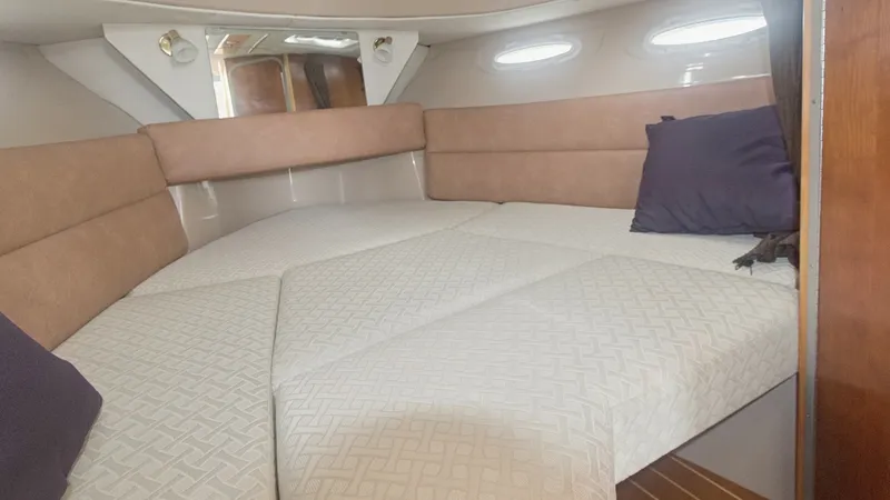 Slide: The Image of Spacious V-Berth Cabin This cozy V-berth cabin on the 2014 Cutwater 28 Downeast offers a comfortable sleeping area with plush cushioning and elegant upholstery. Natural light filters through the side windows, enhancing the warm tones of the wood finishes. The cabin's smart desi - 7180678