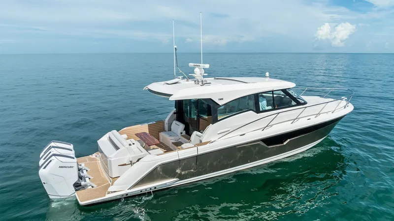 Slide: The Image of Starboard View of Tiara 48LE The Tiara 48LE boasts a sleek starboard profile, showcasing its modern lines and elegant design. The spacious aft deck features comfortable seating, perfect for socializing or relaxing while enjoying the open water. Equipped with powerful outboard engines - 7403597