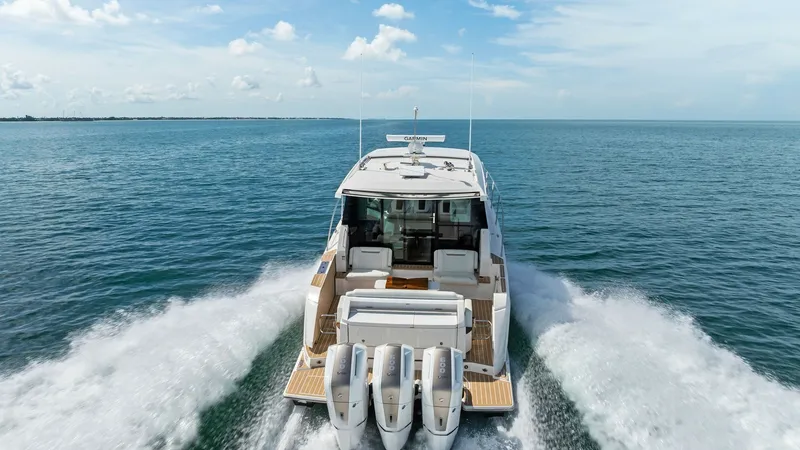 Slide: The Image of Aft Deck with Triple Outboard Engines This stunning view showcases the aft deck of the 2025 Tiara 48LE, equipped with triple powerful outboard engines for exceptional performance. The spacious deck provides ample seating with luxurious finishes, perfect for social gatherings or relaxing at se - 7403675