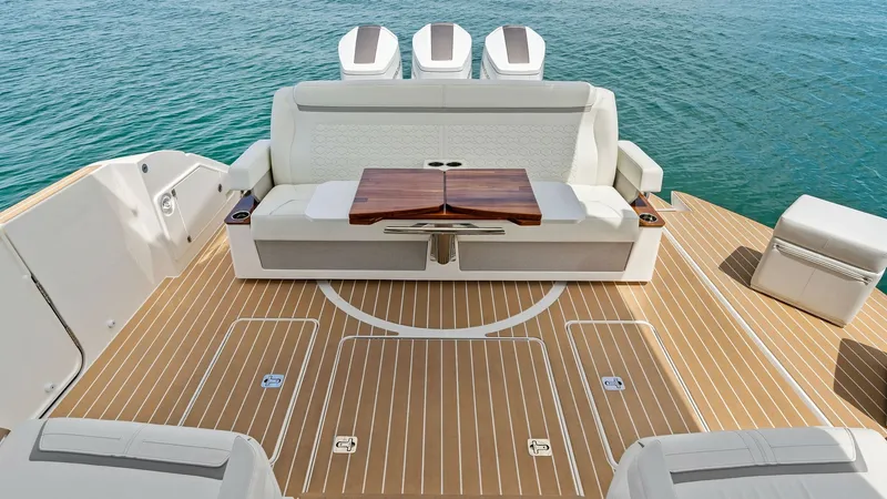 Slide: The Image of Spacious Aft Deck with Seating This elegant aft deck features ample seating with plush white upholstery, perfect for relaxing or entertaining. The teak flooring adds a touch of luxury, complemented by a stylish wooden table at the center. The open layout offers stunning views of the su - 7403614