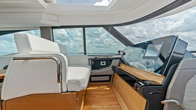 Slide: The Image of Helm Station with Panoramic View The helm station of the 2025 Tiara Yachts 48LE features an ergonomic design with a sleek, modern dashboard equipped with advanced navigation technology. The captain's seat offers plush comfort, positioned to enjoy expansive panoramic views through large w - 7403636