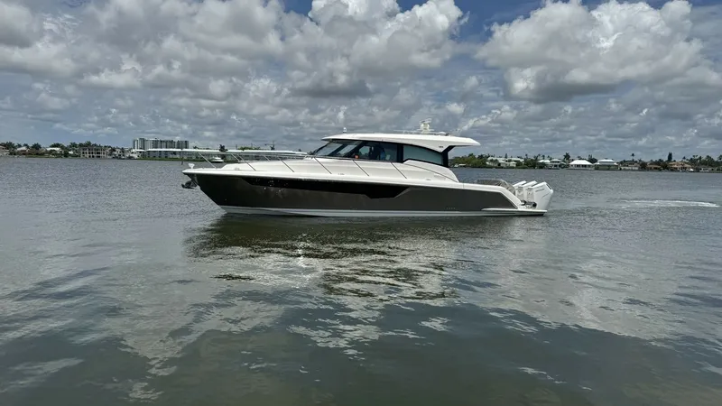 Slide: The Image of Side Profile of Tiara 48LE This image showcases the sleek side profile of the 2025 Tiara Yachts 48LE. The vessel's elegant lines and modern silhouette are complemented by the expansive windows along the hull, offering panoramic views. The hardtop design provides an aerodynamic look - 7179511
