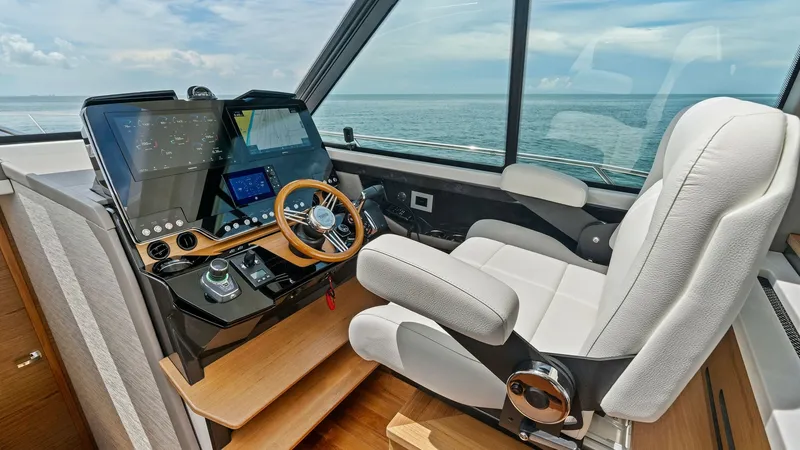 Slide: The Image of Modern Helm Station with Ocean View The helm station of the 2025 Tiara Yachts 48LE features a sleek design with state-of-the-art navigation technology. A plush, ergonomic captain's chair offers comfort while commanding the vessel. Expansive windows provide panoramic ocean views, enhancing t - 7403632