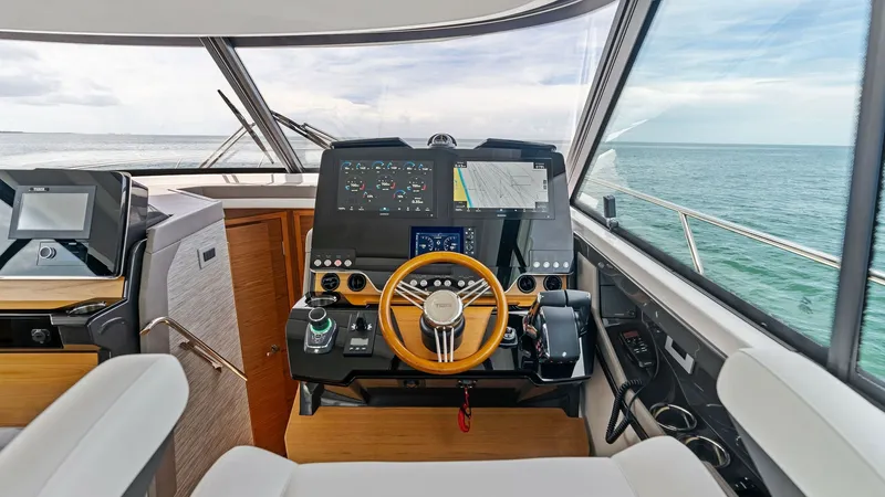 Slide: The Image of Modern Helm Station with Ocean View The helm station of the 2025 Tiara Yachts 48LE offers a commanding view with its expansive windows and state-of-the-art navigation systems. The sleek console features advanced electronic displays, a polished steering wheel, and intuitive controls for a se - 7403631