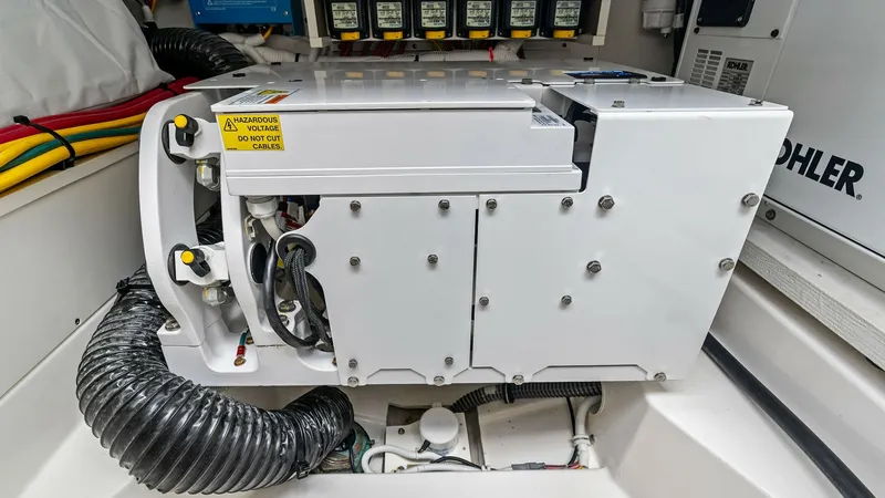 Slide: The Image of Engine Room Electrical Components This image showcases the well-organized engine room of the 2025 Tiara Yachts 48LE, featuring advanced electrical components. The neatly arranged cables and modern equipment emphasize efficient power management and safety. The professional layout ensures e - 7403665
