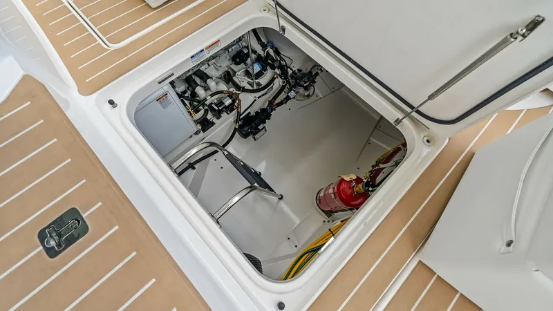 Slide: The Image of Engine Room Access Hatch This image showcases the access hatch to the engine room, featuring a neatly organized layout typical of Tiara Yachts' commitment to quality and precision. The hatch reveals essential components and systems, including a fire extinguisher, ensuring safety - 7403660
