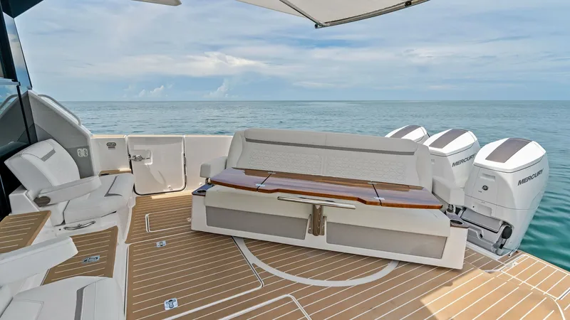 Slide: The Image of Spacious Aft Deck with Seating This aft deck of the 2025 Tiara Yachts 48LE offers a blend of luxury and functionality, featuring a comfortable seating area with sleek, modern upholstery. The spacious deck is adorned with elegant teak flooring, providing a perfect space for relaxation o - 7403602