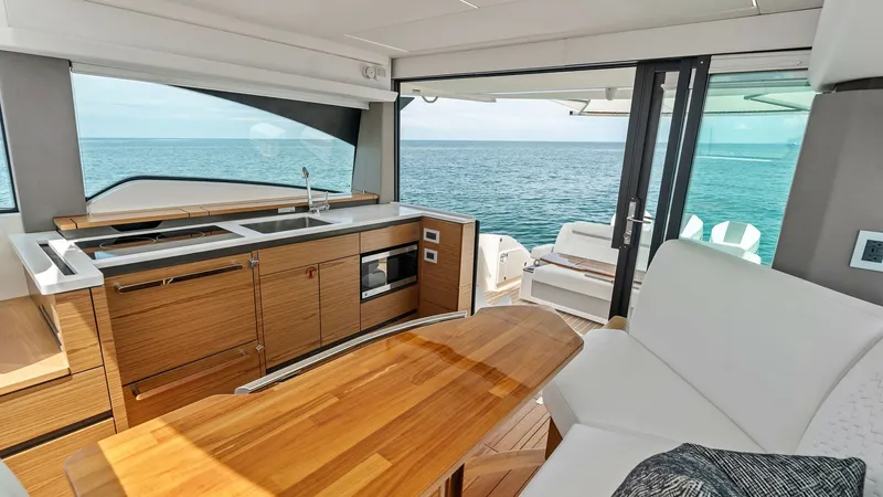 Slide: The Image of Galley and Aft Deck View This elegant galley on the Tiara Yachts 48LE offers sleek wood cabinetry and modern appliances, ensuring style and functionality. The open layout seamlessly connects to the aft deck, providing stunning ocean views and easy access for entertaining. Enjoy t - 7403624