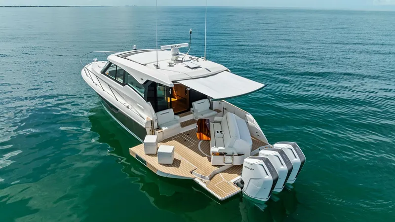 Slide: The Image of Aft Deck with Outboard Engines The aft deck of the 2025 Tiara Yachts 48LE showcases a spacious, teak-finished area perfect for relaxation and entertainment. Equipped with multiple outboard engines, this vessel promises powerful performance on open waters. Comfortable seating and a mode - 7403599