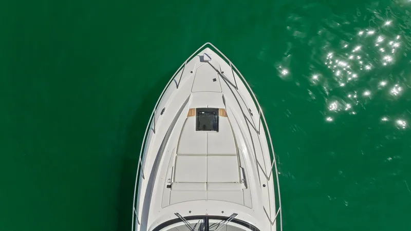Slide: The Image of Aerial View of Bow This aerial shot of the 2025 Tiara Yachts 48LE highlights the sleek and spacious bow area. The foredeck features a comfortable sun pad, perfect for relaxation, with a stylish hatch for cabin access. The elegant lines and pristine finish are complemented b - 7403594